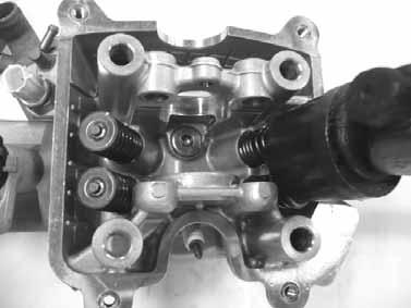 6. CYLINDER HEAD/VALVES DOWNTOWN 125i Cylinder head Check the spark plug hole and valve areas for cracks. Check the cylinder head for warpage with a straight edge and feeler gauge. Service Limit: 0.