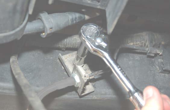 Remove the stock rear brake line bracket from the frame using a 0mm wrench. See Photo.