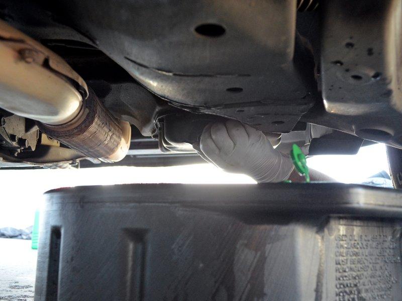 Use a 17 mm socket wrench or box end wrench to loosen the oil drain plug until it is loose enough to turn by hand.