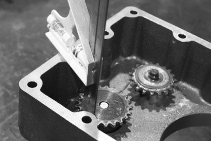 Adjustment is made on the oil pump sprocket to match the dimensions that are measured from the housing face to the idler sprocket.