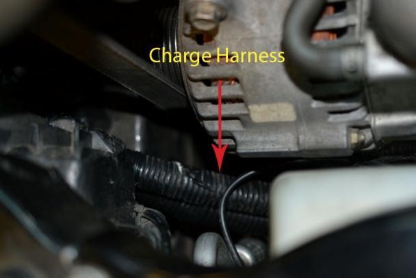 From under the car push the new harness up by the A/C compressor and route the harness between the
