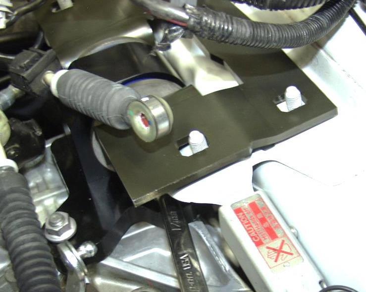 a) Remove the two (2) shifter cable bracket bolts with a 12mm socket wrench and long extension (red circles in Figure 5a).
