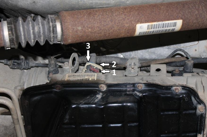 To remove connector, push red tab (1) downwards. Then, press the black tab (2) which will allow the white handle (3) to be rotated downwards, releasing the connector from the transmission. 6.