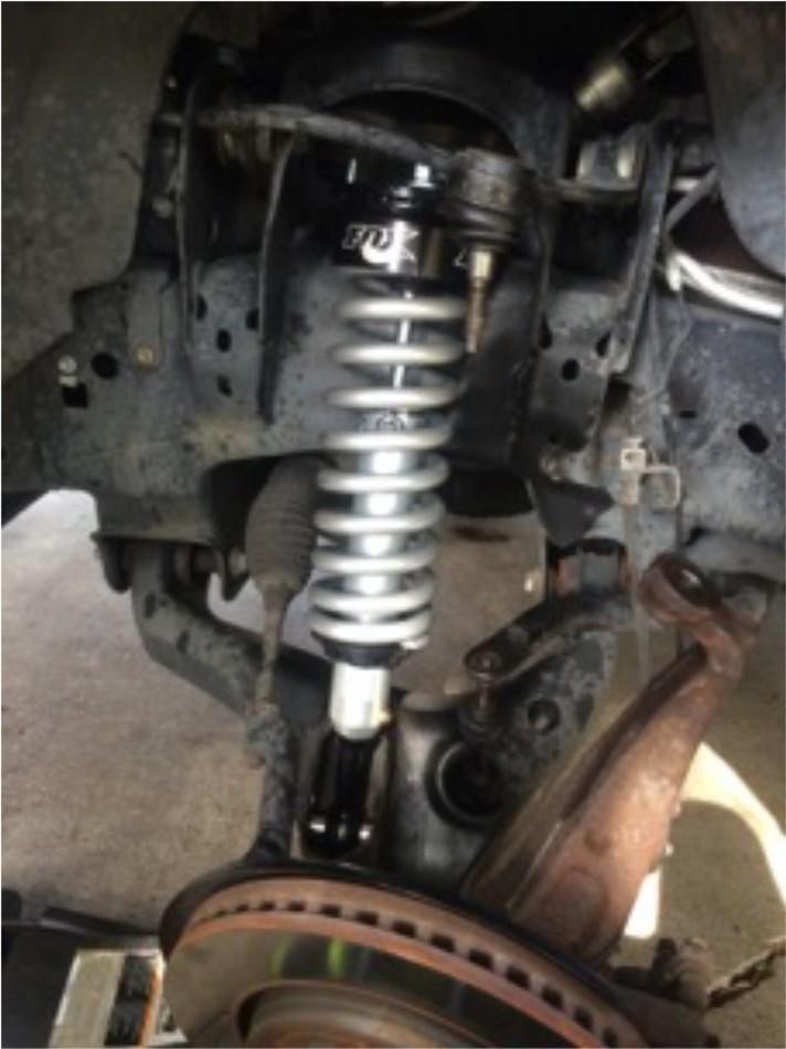 It may be easier to place the strut in top first and them slide the bottom into place, insert the new lower strut bolt and hand tighten the lower strut nut but do not torque down yet.