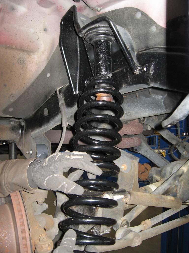3. Repeat steps 1 and 2 on the remaining side of the vehicle. 4. Carefully lower the front axle to ease in the new coil spring installation.