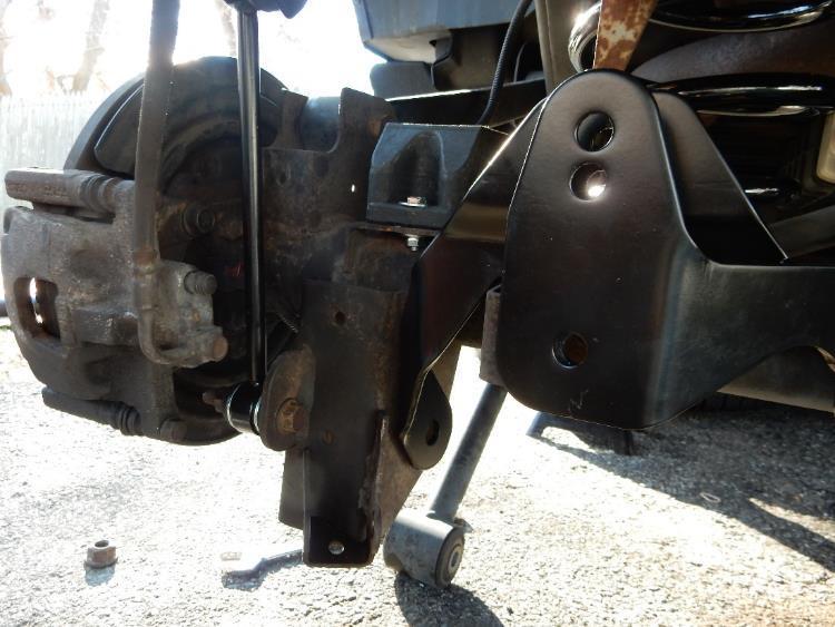 Position the rear axle track bar bracket over the