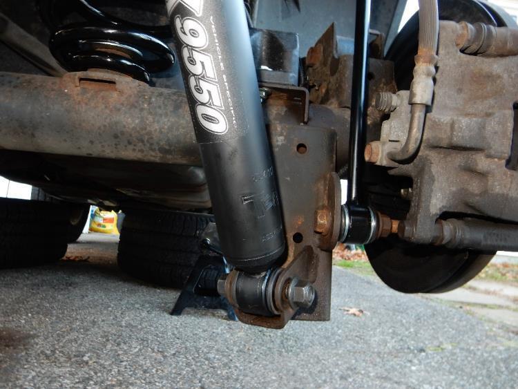 sides. Torque to 37 ft-lbs. 33. Position the new rear shocks in place, aligning the lower bolt holes.