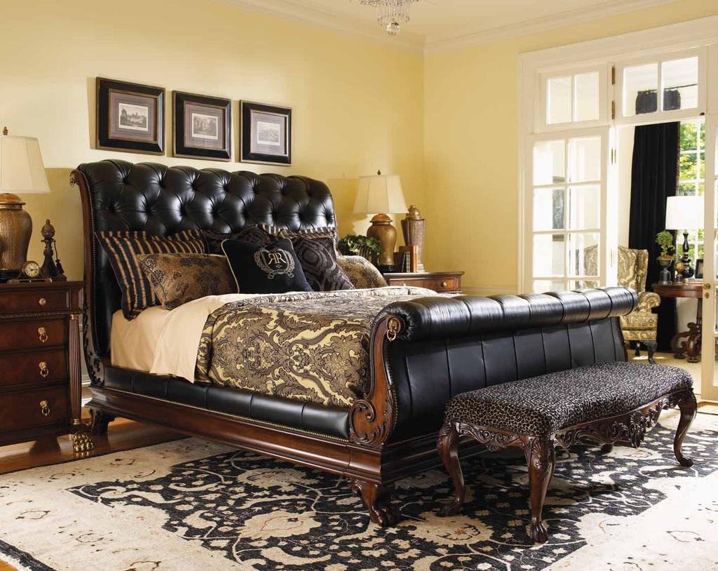 The headboard and footboard feature intricate carvings on the posts, capped with solid brass decorative hardware.