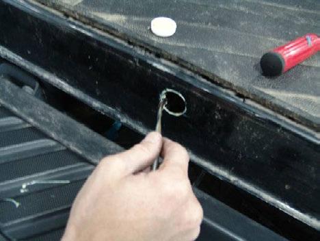 With an assistant, remove the tailgate by lifting away from lower tension pins, and set tailgate