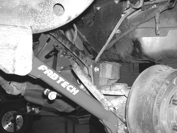 Remove the coil springs and discard. 30. Remove the factory rubber bump stop and discard. 31. Locate the new Fabtech rear track bar bracket FT50053BK. Place the bracket on factory axle mount.