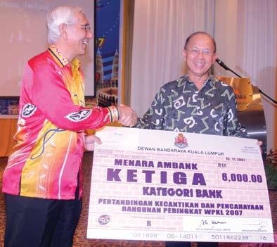 Timbalan Menteri FT, YB Datuk Wira Abu Seman Yusop (kiri) menyampaikan cek contoh kepada Pengerusi Kumpulan AmBank, Tan Sri Dato