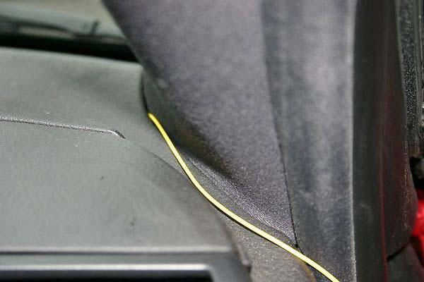 7 Carefully push the black StealthOne K-BUS wire into the seam between the dashboard and the