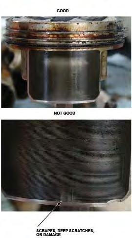 32. Remove the piston from the scratched cylinder bore. Inspect the piston skirt for any scratches or damage that corresponds with the scratched cylinder bore.