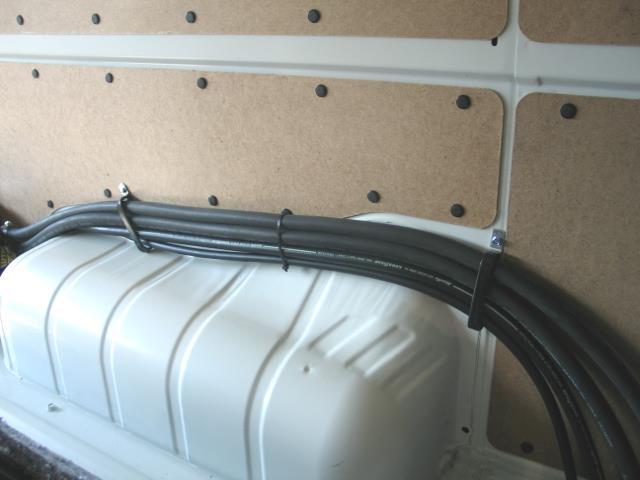 13. Gather the refrigerant hoses (2), heater hoses (2), and Evaporator harness into a bundle and route them over the