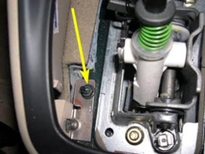 33. When both 10mm nuts are off, raise the front of the bracket over the posts that the nuts were on and then slide the bracket backward and out from underneath the lower center console