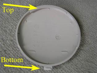 5. Remove the rear ashtray housing by carefully prying up the two tabs on each side with a screwdriver, as shown in