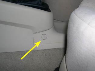 Pry out the trim tab on both sides of the e-brake console indicated