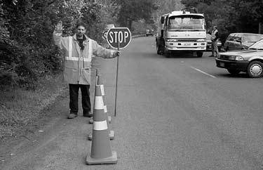 7 Directing traffic Before you stand in or beside a lane to direct traffic, make sure you slow approaching road users down by using cones and/or signs.