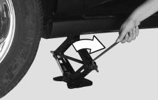 3. Remove any rust or dirt from the wheel bolts, mounting surfaces and spare wheel. CAUTION: 2. Raise the vehicle by turning the jack handle clockwise.