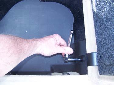 Remove the Bose system in the driver side rear compartment, if equipped. It is fastened with three bolts that can be reached with a long extension on a ratchet, and it is glued down with putty.