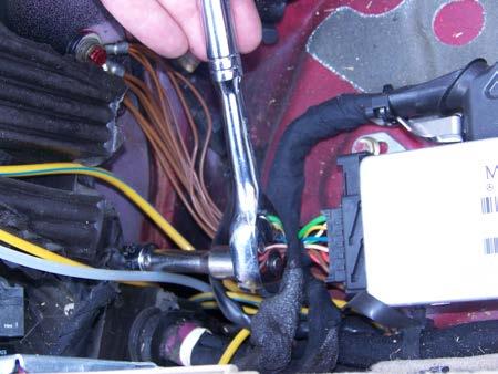Remove the passenger side compartment floor panel with a 10-mm wrench or socket. Find the 14-mm hex head for the main cylinder s bottom bolt. It is below (not behind) a bunch of wires and foam rubber.
