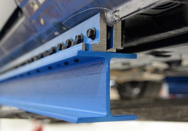 Any trim or other components are removed if they interfere with supporting the vehicle along its rocker panels.
