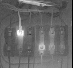 Overheated fuses shown in the thermogram of Fig. 10 appear at the left and center of the thermogram.