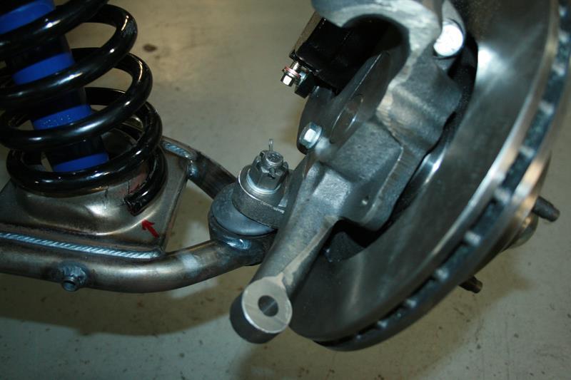 Installing the spindle assemblies: Place the spindle onto the lower ball joint with the steering arm facing forward with the large I/D tie rod end taper facing down.