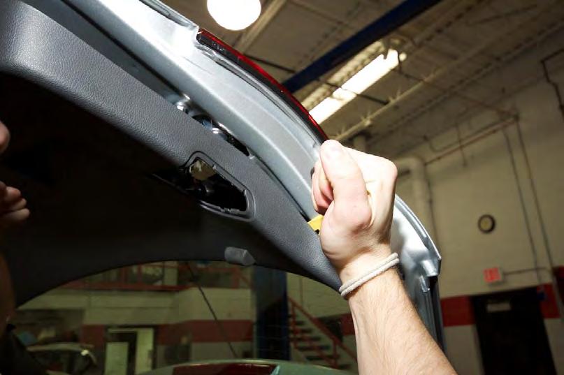 Install the Camera Step 1-3 Pry the rear hatch trim panel away from the hatch using a plastic,