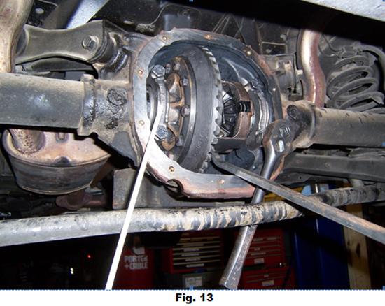 14. Remove pinion oil seal from front end of housing by carefully lifting seal flange away from housing, by tapping a chisel or thin blade screw driver around entire seal as in Fig. 14.