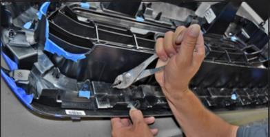 Flip the grille assembly over and place on a Padded Work Surface to begin disassembly