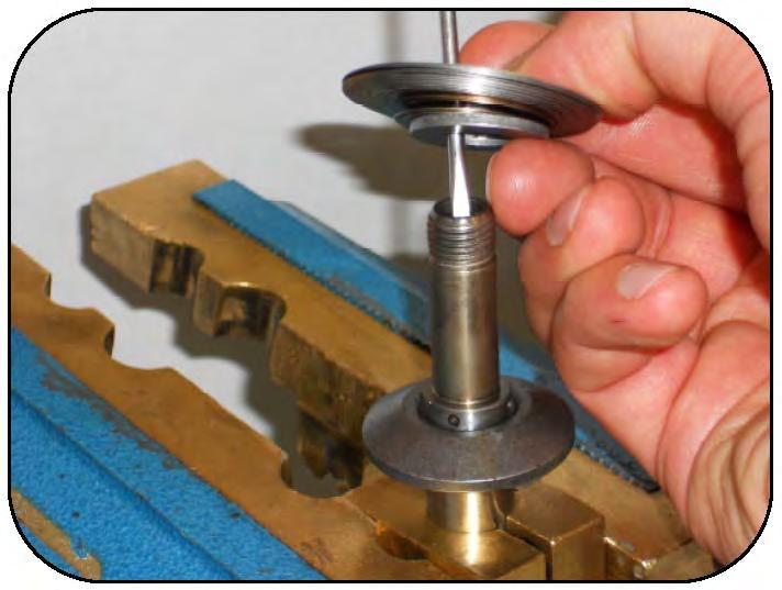 Lock the shaft into the vise using the brass