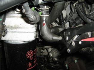 under the coolant reservoir (see picture).