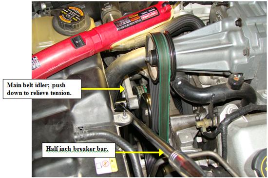 2. Relieve the accessory belt drive tension using a half in drive (no socket
