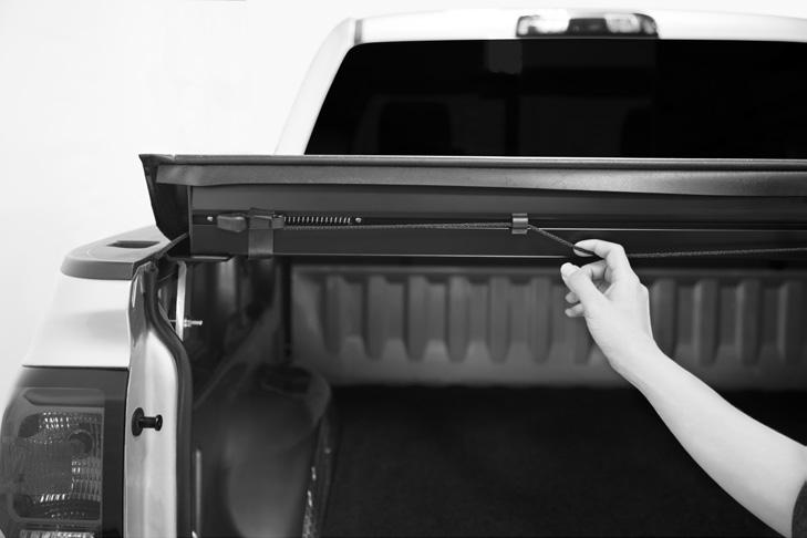 Open tailgate, pull down AUTOLATCH II Locking System's cord and rotate rear bar
