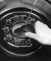 7. Tilt the retainer plate at the end of the cable, when the tire has been lowered, and pull it through the wheel opening. 8. Pull the tire out from under the vehicle.