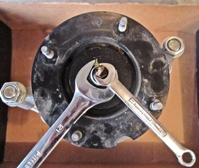 16. Using the attached Spring-Compressor tool, further compress the spring until the tension is relieved from the upper