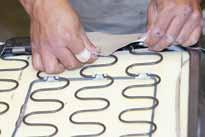 Clamp hog rings around the retainer wires and vinyl to a convenient point on the steel S shaped springs (see figure