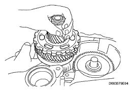 Then, using the ribbed part of the rear differential carrier as a fulcrum, disconnect the left and right rear drive shafts.