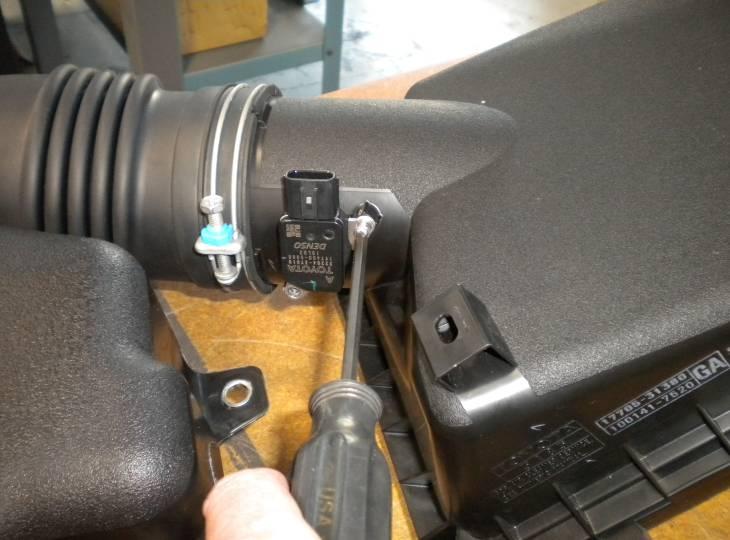 22. Remove the MAF sensor from the OEM upper air box by removing the two philips head screws. (Fig. D25) i. Take care to not damage the sensor. 23.