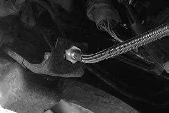 Save the rear brake line clip. Remove the brake line from the frame location and the distribution block located on the rear differential. The brake line may be discarded.