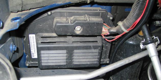 7b C44073 Kit Only: On the passenger side firewall, locate the PCM (shown in fig 7b). Remove the connector by loosening the bolt in the center. Remove the plastic cover to access the wires.
