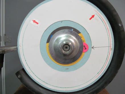 Place an equivalent stack of paper sticky dots between the edge of the inboard cup washer and the surface of the wheel in a position 180 from the dots you placed on the outboard side of the wheel.