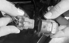 9. Install the appropriate new bulb into the electrical connector. Push the bulb firmly enough so that the gray tabs hook over the tab on the bulb. 10.