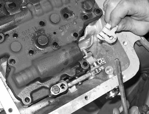 Slide the throttle valve shaft out of the transmission and remove the throttle valve shaft clamp. Fig. 3 and Fig. 4 Step 5: Remove the detent spring. Fig. 5 Loosen the bolt on the selector shaft clamp, but do not remove the bolt.