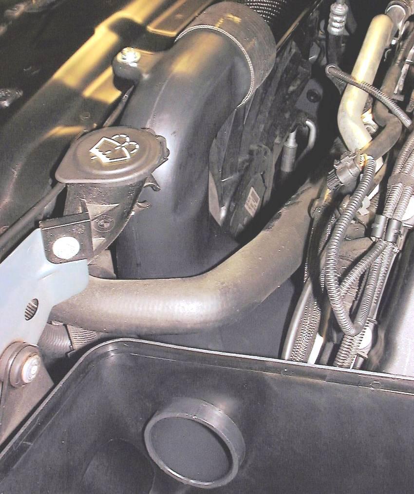 Figure 13 shows how the extra inlet tube gets routed between the radiator hose and oil lines into the lower half of the Dinan Air Box. Fig: 12 12.