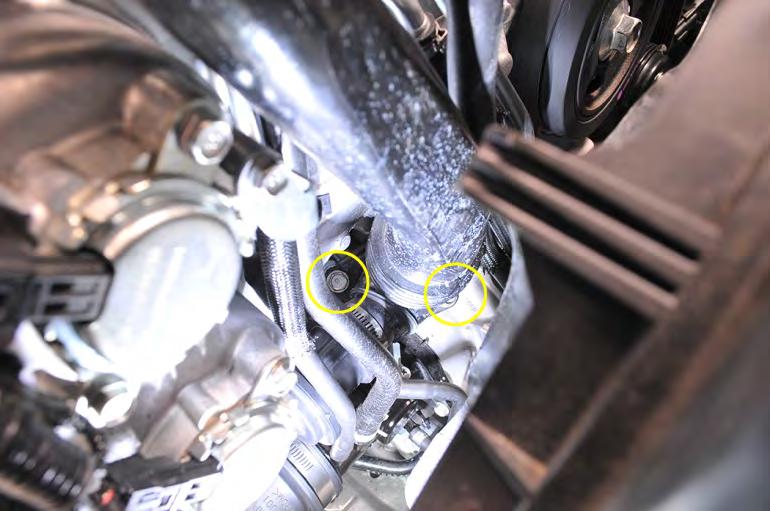 7. Next using a ⅜, 3 long extension, ratchet and 12mm socket remove the (2) 12mm bolts that hold the boost pipe to the turbo.