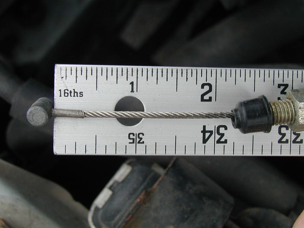 Take note of where on the ruler the throttle cable end is located. Have the helper fully depress the throttle pedal. Take note of the new position that the throttle cable end is on the ruler.