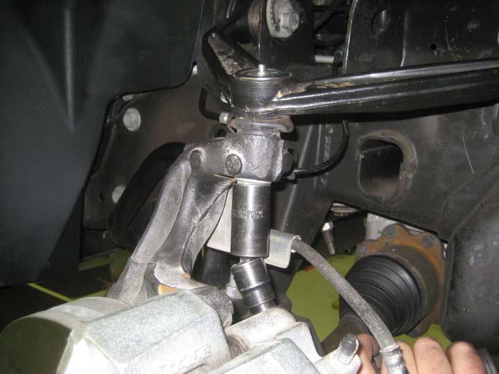 Working on the driver side, remove the hardware attaching the upper control arm to the knuckle.
