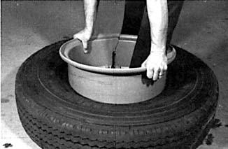 second notch and push downward toward the center of the rim, prying the solid side ring from the rim. Remove side ring. Stand the tire on its tread.